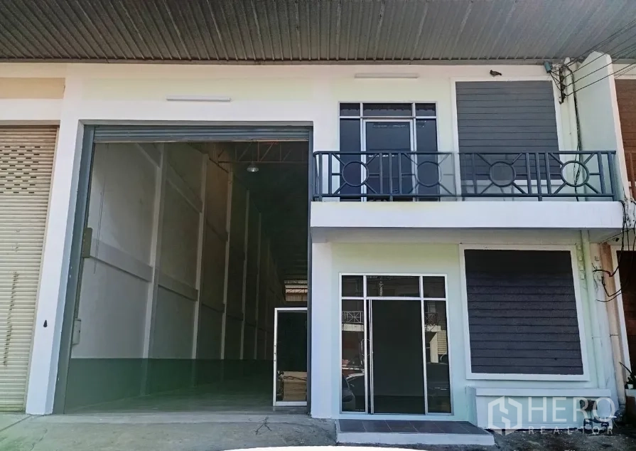 仓库 for rent in Bang Phli, Samut Prakan - 仓库外立面，宽大卷帘门、阳台与独立玻璃入口。