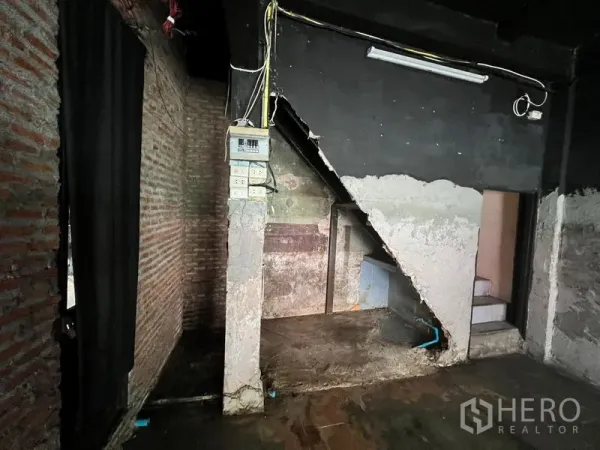 店屋 出租在Phaya Thai, Bangkok - 楼梯下角落，外露红砖、配电箱与水泥表面