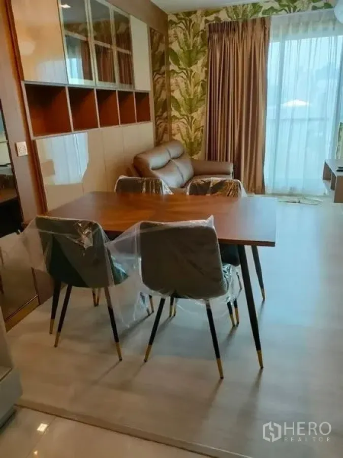 公寓 出租在Pathum Wan, Bangkok - 客餐厅一体空间，吊灯、沙发及带窗帘的阳台。