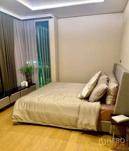 คอนโด ให้เช่าในWatthana, Bangkok - ห้องนอนกว้างยามค่ำ พร้อมฝ้าหลุม พื้นไม้ และผ้าม่านทึบสูง