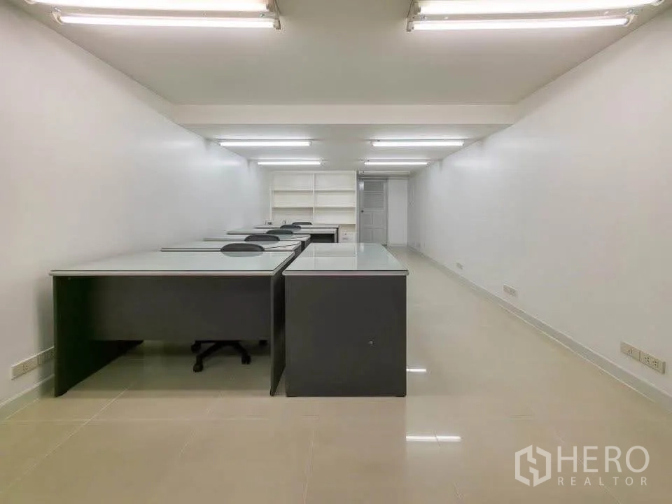 办公空间 出租在Khlong Toei, Bangkok - 纵深办公室，成排工位与长条灯照明。