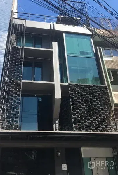 零售空间 出租在Watthana, Bangkok - 现代多层临街建筑，整面玻璃立面，位于瓦他那区。