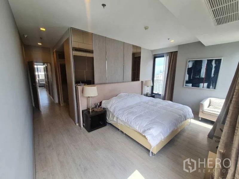 Condominium for sale - Spacious primary bedroom with large windows, a seating corner and custom wardrobes.