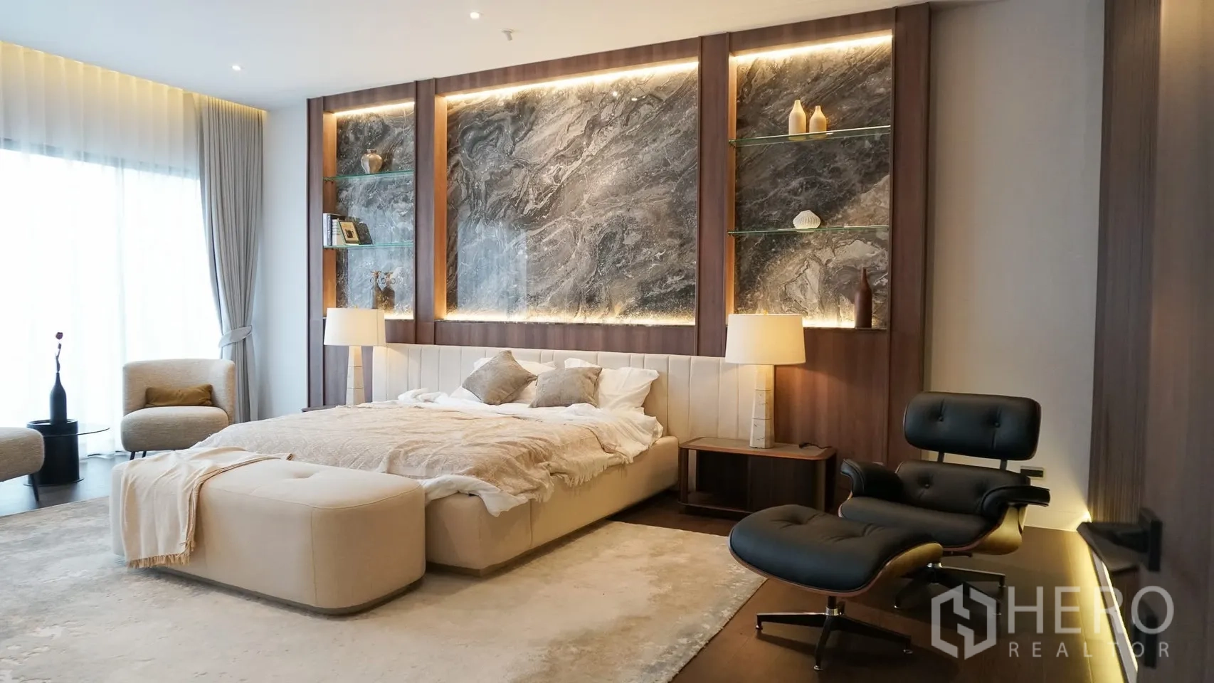 Detached House for rent or sale in Bang Kapi, Bangkok - Master bedroom with illuminated marble headboard feature and seating area.