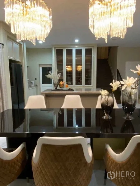 บ้าน ให้เช่าในBang Khen, Bangkok - ห้องทานอาหาร โต๊ะท็อปเงาสีดำ เก้าอี้บุนวม และโคมระย้าคริสตัล