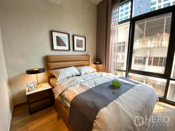 公寓 出租在Watthana, Bangkok - 次卧带大窗与棕色床头柜，都市景观一览。