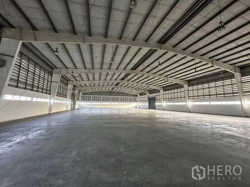 Factory for rent in Khlong Luang, Pathum Thani - Clear-span production hall with arched steel roof, hanging lights and wide open workspace.
