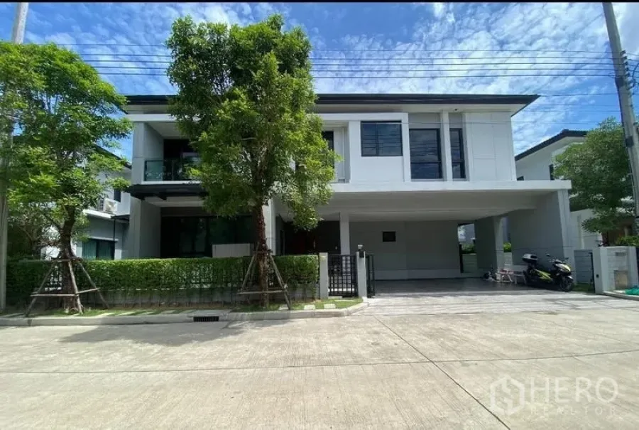 Detached House for sale in Saphan Sung, Bangkok - Front facade of the detached house with covered parking and mature trees.