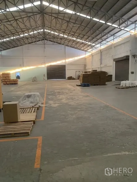 仓库 for rent in Bang Phli, Samut Prakan - 开阔的仓库通道通向大型卷帘装卸门。