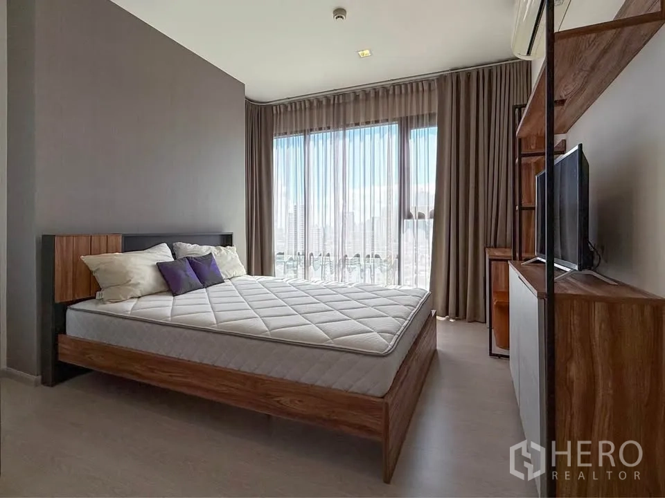 公寓 for rent in Khlong Toei, Bangkok - 宽敞房间，设床、电视柜与带纱帘的全景窗。