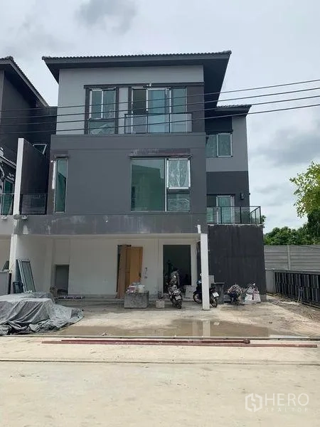 บ้าน ขายในPrawet, Bangkok - บ้านเดี่ยวสไตล์โมเดิร์นสูง 3 ชั้น โทนเทาเข้ม หน้าต่างบานใหญ่ ระเบียงกว้าง พร้อมที่จอดรถหน้าบ้าน