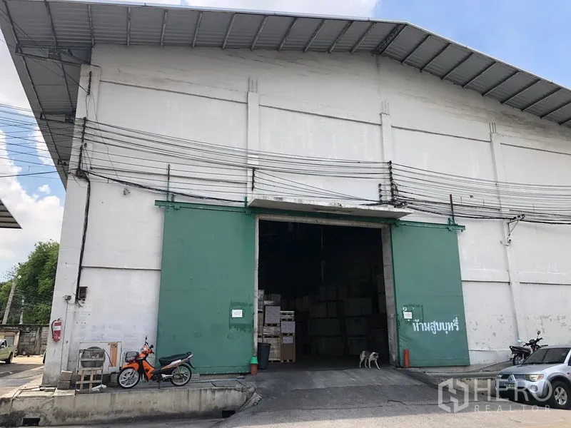 คลังสินค้า ให้เช่าในRat Burana, Bangkok - ภายนอกโกดังอุตสาหกรรม เพดานสูง ประตูเหล็กสีเขียวขนาดใหญ่ ทางเข้าขนส่งกว้าง และลานคอนกรีต ในเขตราษฎร์บูรณะ กรุงเทพฯ