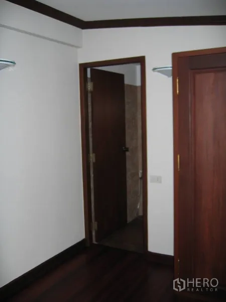独立式住宅 出租在Watthana, Bangkok - 小房间通往浴室的门，旁为木质衣柜。