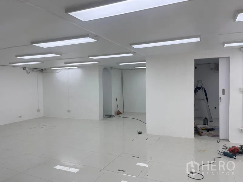 Retail Space for rent in Khlong Toei, Bangkok - Corner of the retail unit with doorway and arched niche under LED lighting.