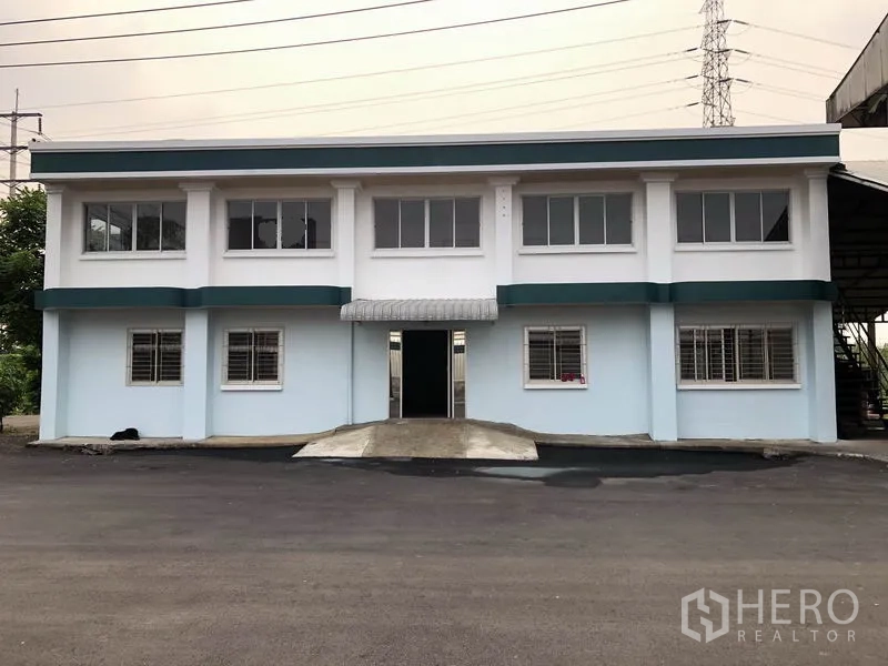 Factory for rent in Lam Luk Ka, Pathum Thani - Front view of a freshly painted two‑storey office building with barred windows.