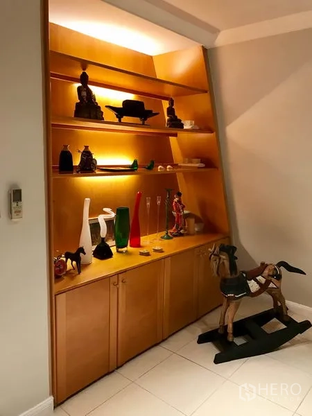 Condominium for rent in Bang Rak, Bangkok - Built-in wooden display shelves with accent lighting showcasing decorative pieces.