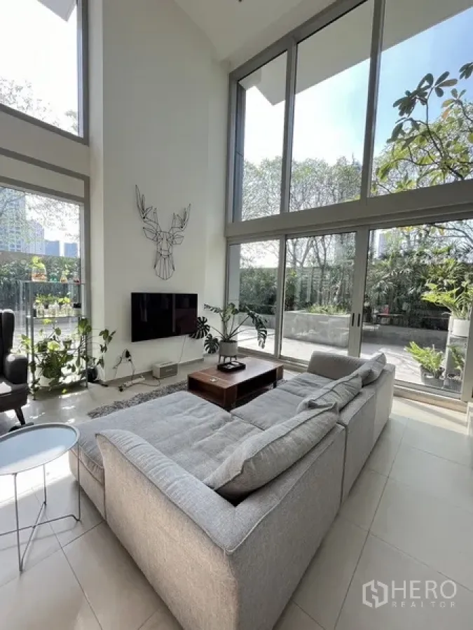 公寓 出售在Khlong San, Bangkok - 挑高客厅，整面落地窗与绿意露台相连