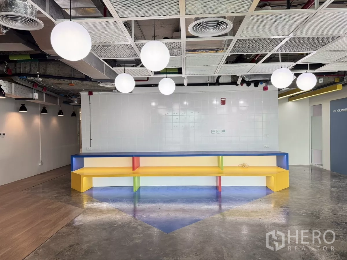 Office Space for rent in Din Daeng, Bangkok - Breakout area featuring a long colorful bench beneath modern pendant lights.