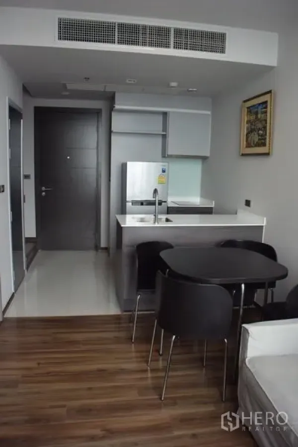 公寓 出租在Watthana, Bangkok - 开放式厨房带中岛吧台、圆形餐桌与木地板的Ekkamai公寓。
