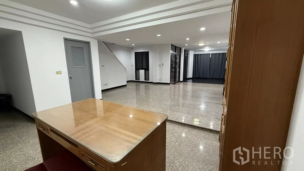 Home Office for rent in Bang Na, Bangkok - Open-plan ground floor with polished stone floors, recessed lighting, staircase and glass partitions.