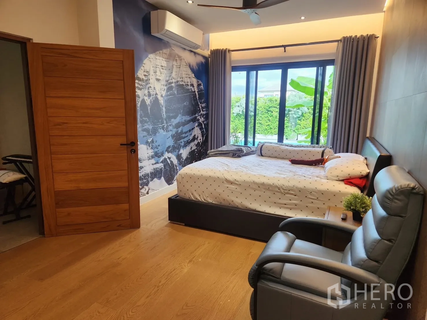 บ้าน ให้เช่าในBang Phli, Samut Prakan - ห้องนอนมองเห็นสระว่ายน้ำผ่านประตูกระจก พร้อมภาพผนังพาโนรามา