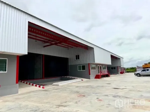 Warehouse for rent in Bang Bo, Samut Prakan - Row of warehouse units with a wide concrete driveway for trucks.