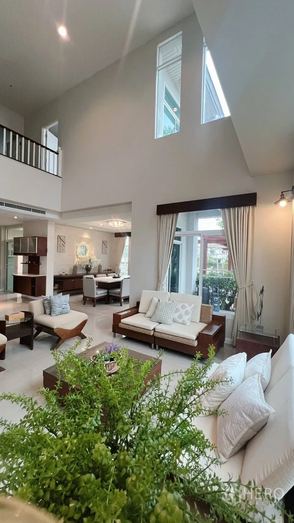บ้านเดี่ยว for rent in Lat Krabang, Bangkok - มุมมองจากห้องนั่งเล่นไปยังครัวและบันไดพร้อมโซฟาสมัยใหม่