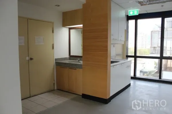 办公空间 出租在Watthana, Bangkok - 茶水间角落，配水槽、石质台面与橱柜，临近大窗。