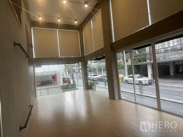 带办公室的家 出租在Suan Luang, Bangkok - 临街展示厅，可见高窗帘与推拉玻璃门及前方平台。