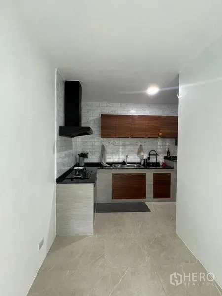 Townhouse for rent - Separate kitchen corridor with L-shaped counter and white subway-tile backsplash.