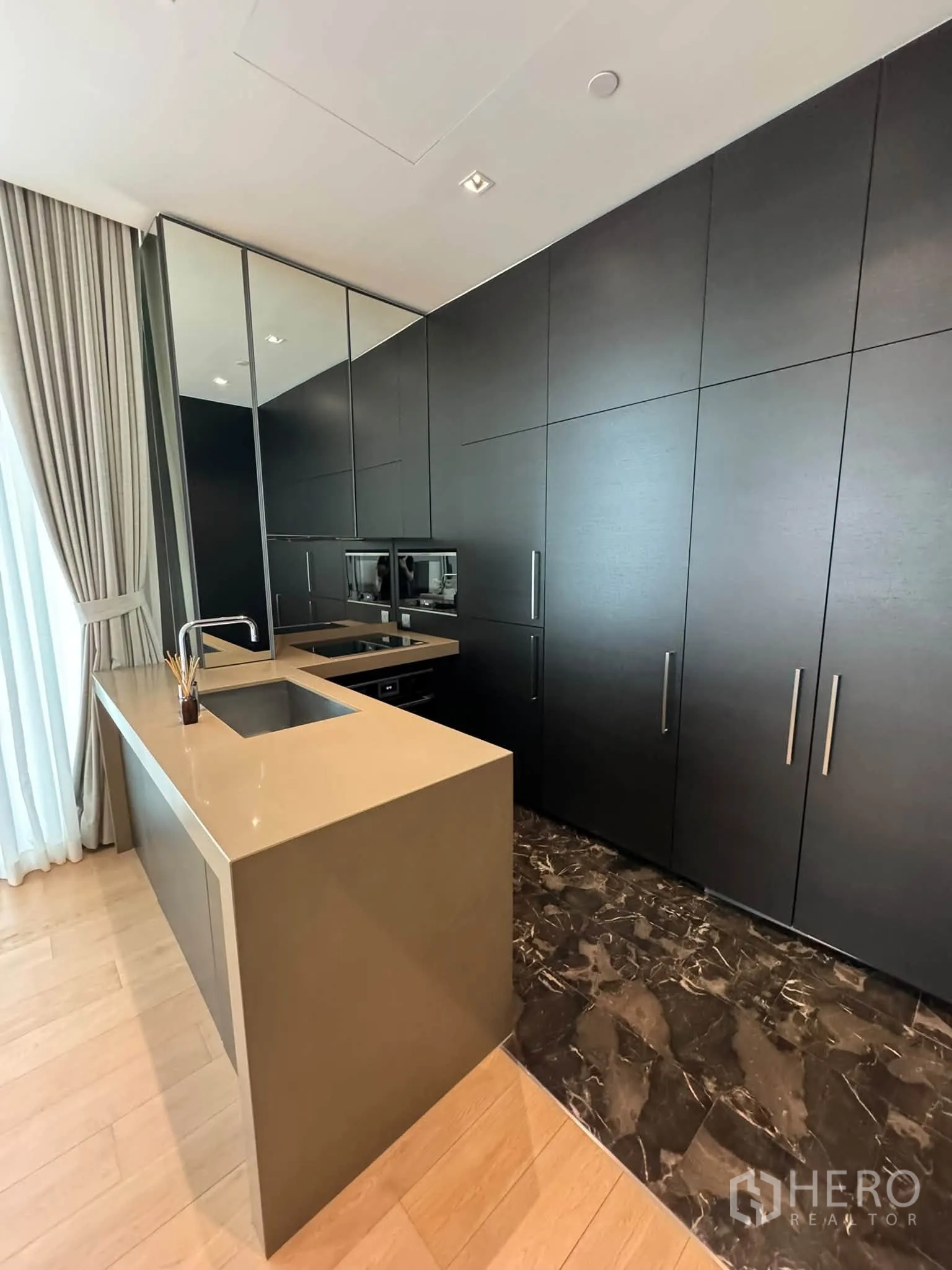 Condominium for rent in Pathum Wan, Bangkok - Kitchen angle showing built-in appliances and extensive full-height storage.