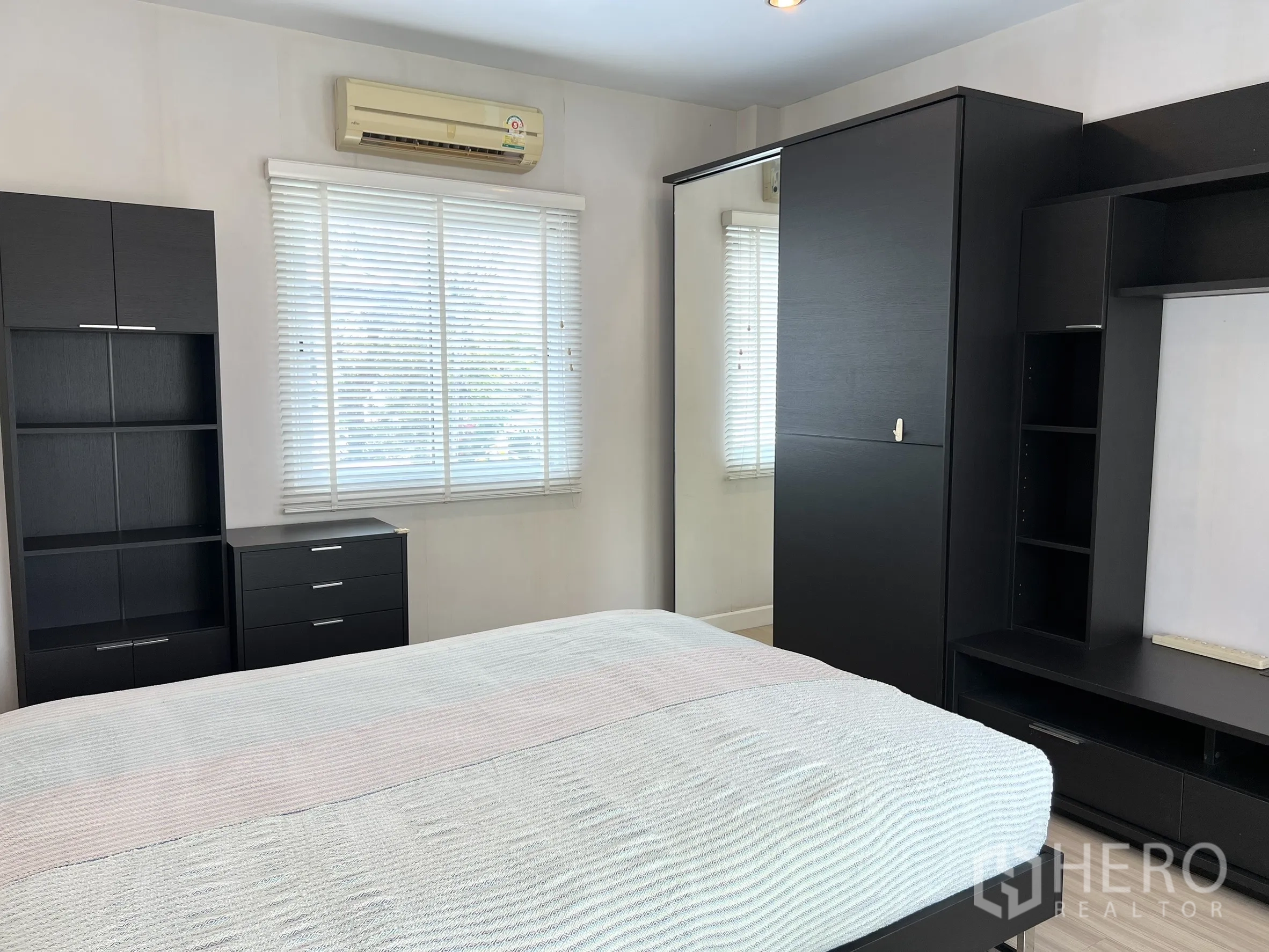 独立式住宅 出租或出售在Saphan Sung, Bangkok - 次卧，黑色家具、大窗与空调。