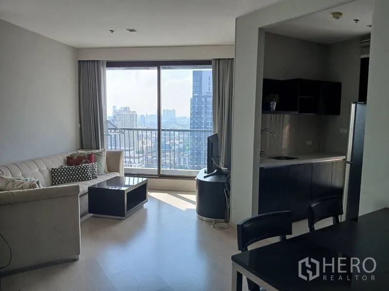 Condominium for rent - Another angle of the living area opening to the balcony and compact kitchenette with city view.