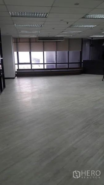 Office Space for rent in Huai Khwang, Bangkok - Open area with light wood floors and large windows fitted with roller blinds.