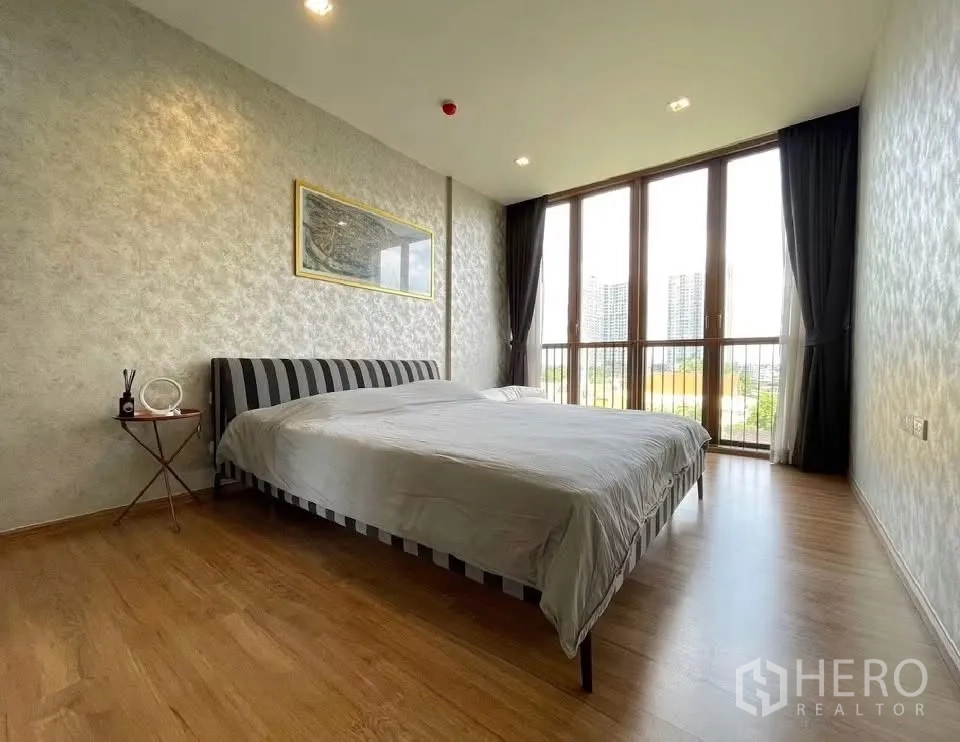 Condominium for rent in Watthana, Bangkok - Spacious bedroom with large bed and wall-to-wall windows offering city views.