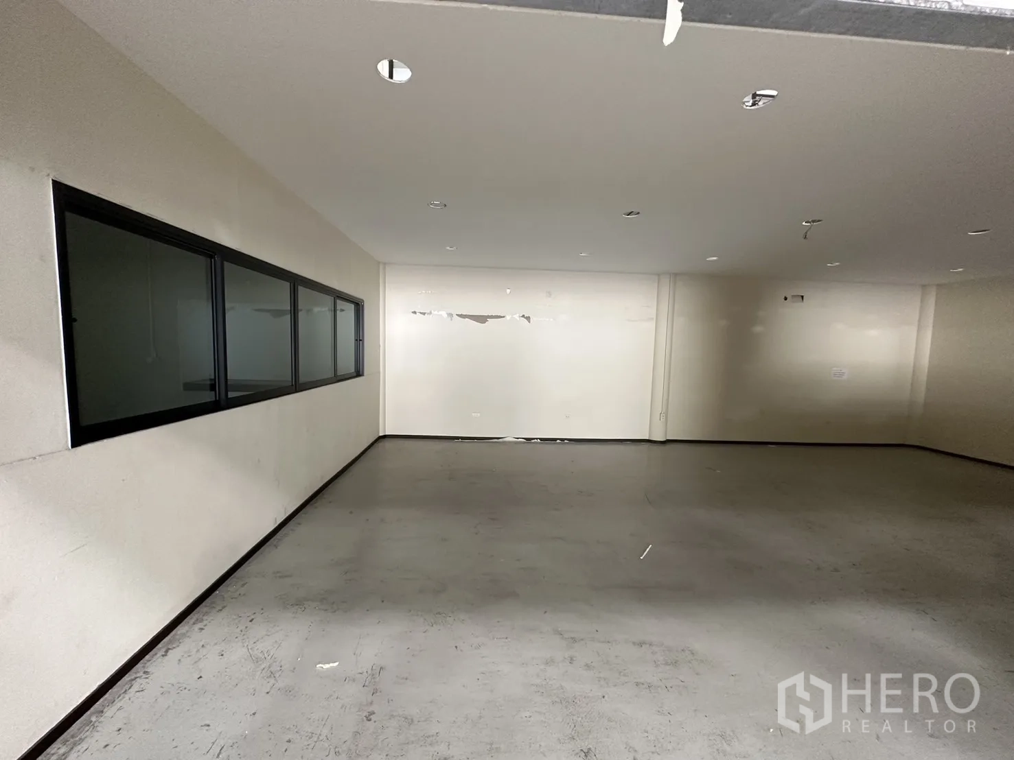 Warehouse for rent in Suan Luang, Bangkok - Ground-floor office room with a long internal observation window facing the warehouse.