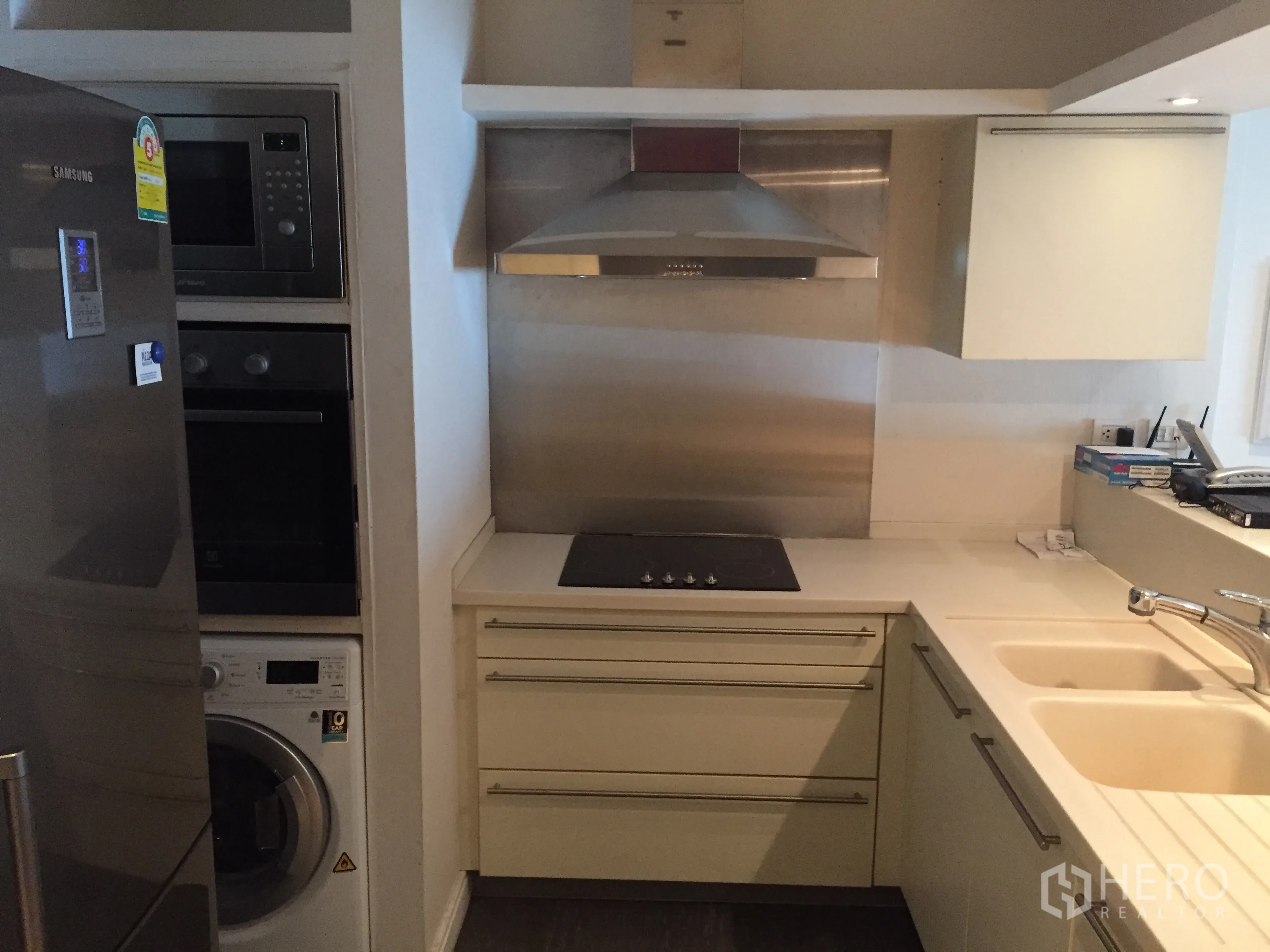 Condominium for rent in Pathum Wan, Bangkok - Compact kitchen corner with built-in oven, microwave, fridge and washer.
