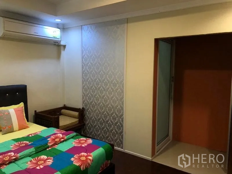 Retail Space for rent in Khlong Toei, Bangkok - Bedroom featuring bright bedding, air conditioning, feature wall and seating nook.