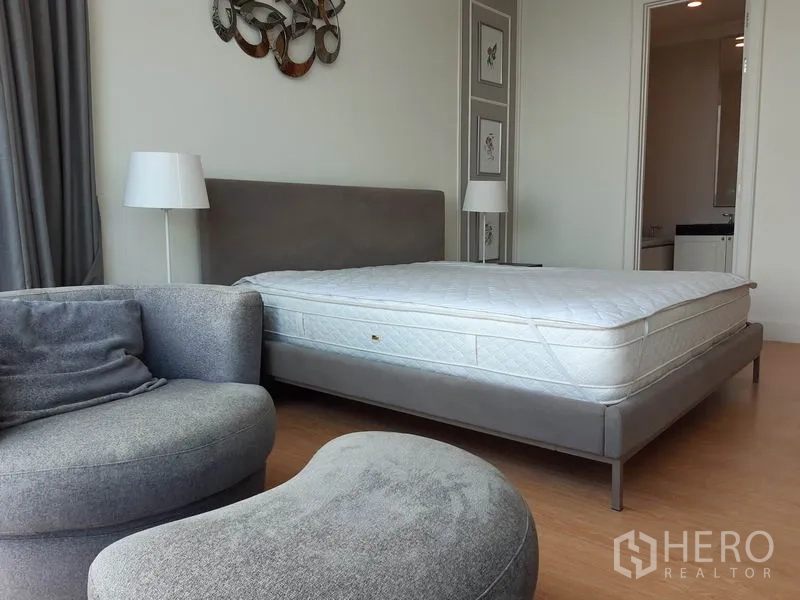 公寓 出租在Watthana, Bangkok - 主卧配软包床与休闲椅，并可进入套内卫浴。