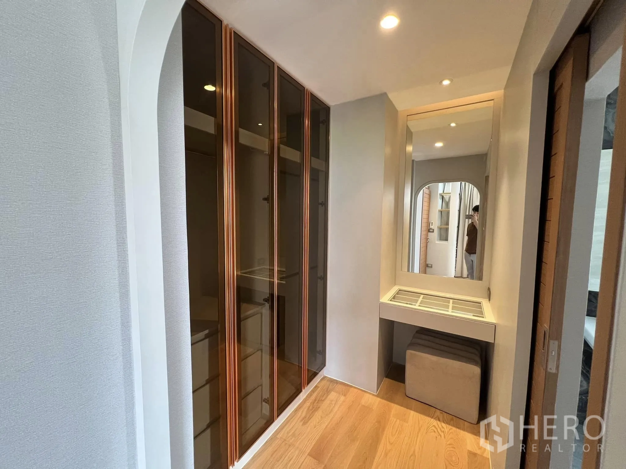 Detached House for rent or sale in Yan Nawa, Bangkok - Walk-in closet corridor with glass wardrobes and a vanity mirror.