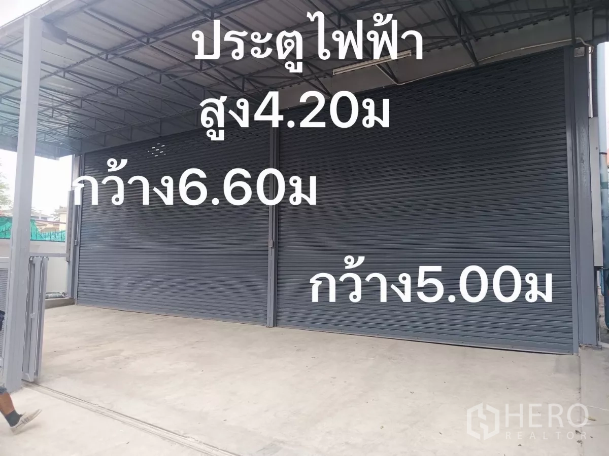 货栈 出租在Huai Khwang, Bangkok - 仓库正面两扇电动卷闸门，位于金属雨棚下。