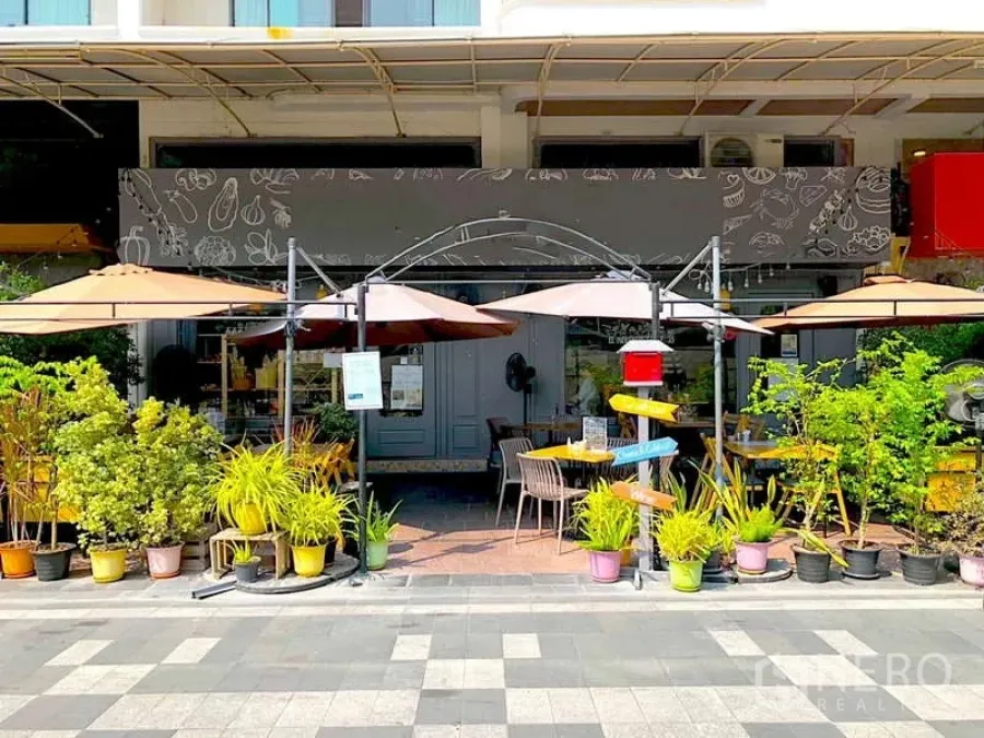 Retail Space for rent in Watthana, Bangkok - Street-level retail frontage with shaded outdoor seating, umbrellas and lush potted plants.