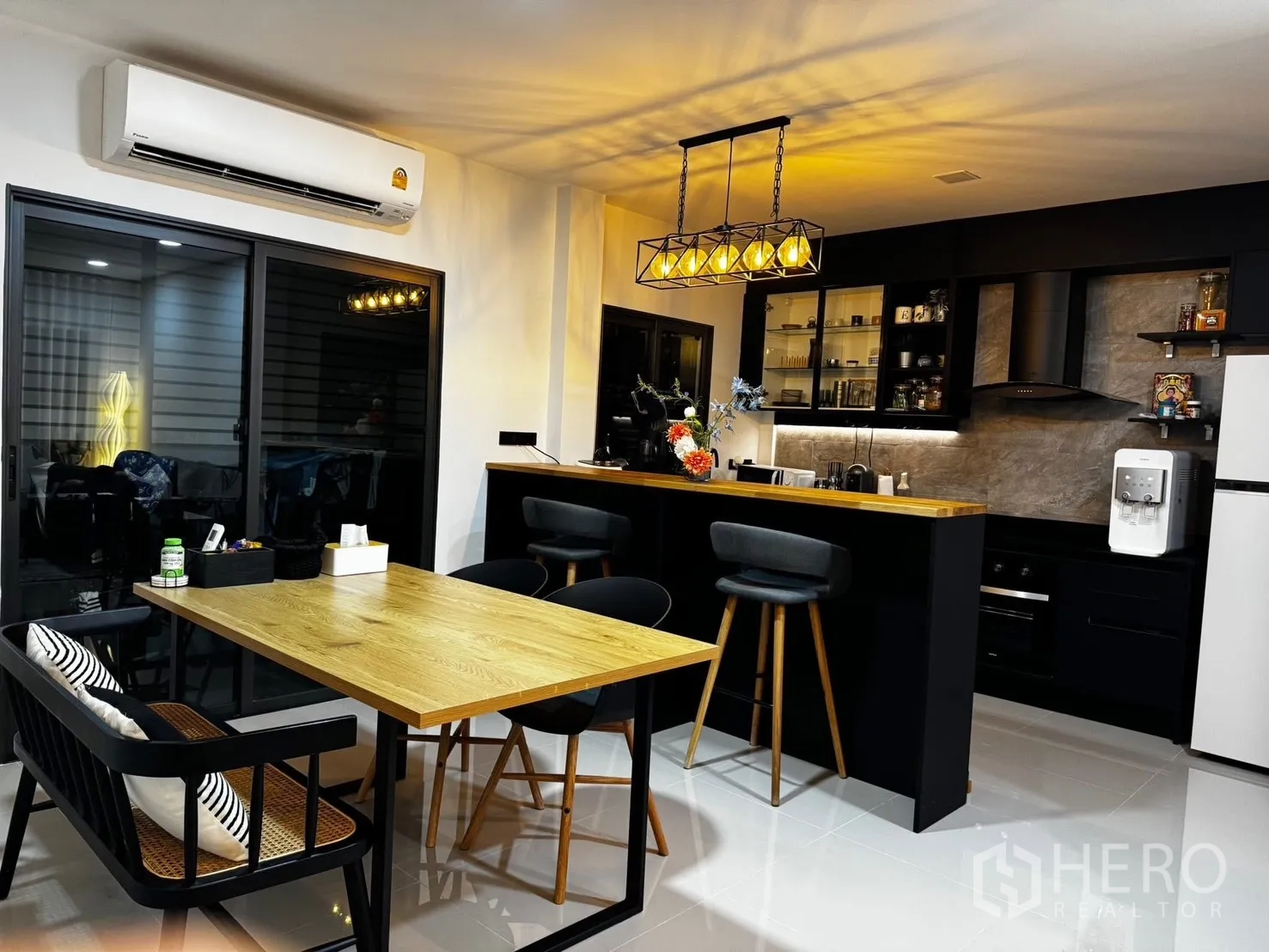 ทาวน์เฮาส์ ให้เช่าในBang Phli, Samut Prakan - พื้นที่รับประทานอาหารเปิดโล่งพร้อมเคาน์เตอร์บาร์ โคมไฟห้อย และประตูกระจกบานเลื่อน