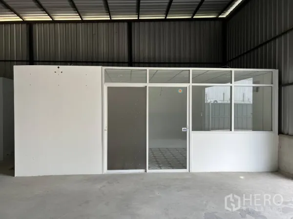 Warehouse for rent in Lat Krabang, Bangkok - Glass-front enclosed office inside the warehouse with sliding door and windows.