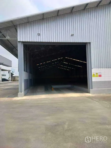 货栈 出租在Lat Krabang, Bangkok - 开启的卷帘门展示大跨度仓库内部