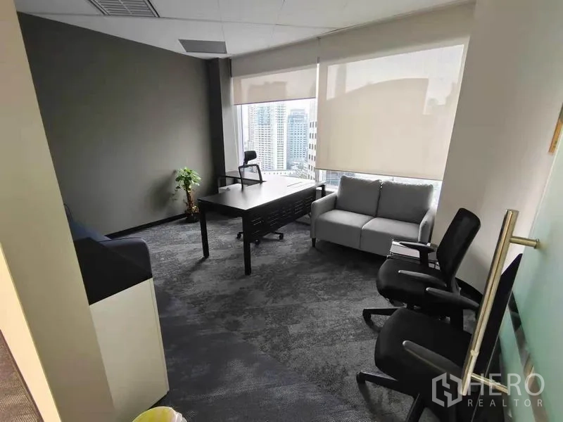 Office Space for rent in Pathum Wan, Bangkok - Private office with grey sofa, work desk and panoramic windows overlooking the CBD.