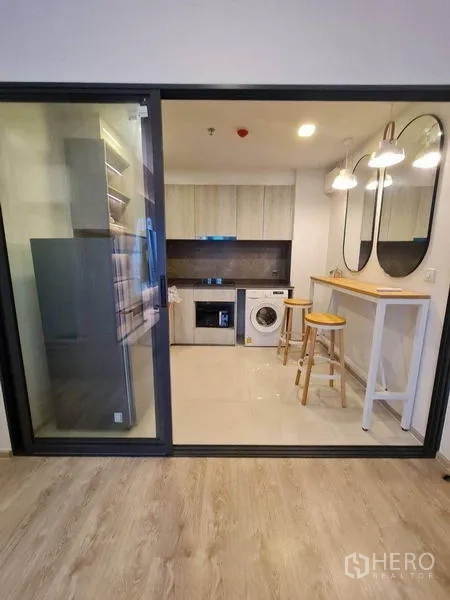 Condominium for rent - Enclosed kitchen behind sliding glass with built-in cabinets, washer and breakfast bar with pendant lights.