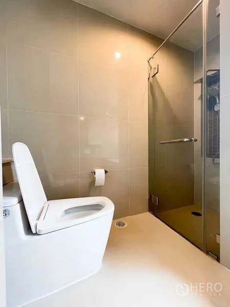 Condominium for rent - Second bathroom with toilet and a frameless glass shower enclosure.