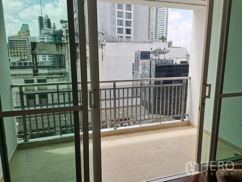 Condominium for rent in Khlong Toei, Bangkok - Private balcony with metal railing overlooking nearby buildings and the city skyline.