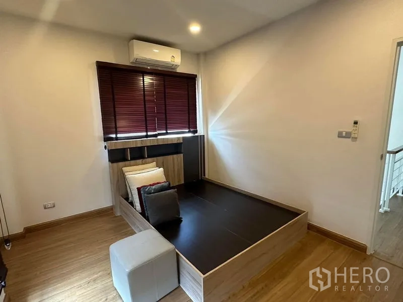 Detached House for rent in Bang Phli, Samut Prakan - Cozy multipurpose room with raised platform bed and cushions on wood floors.